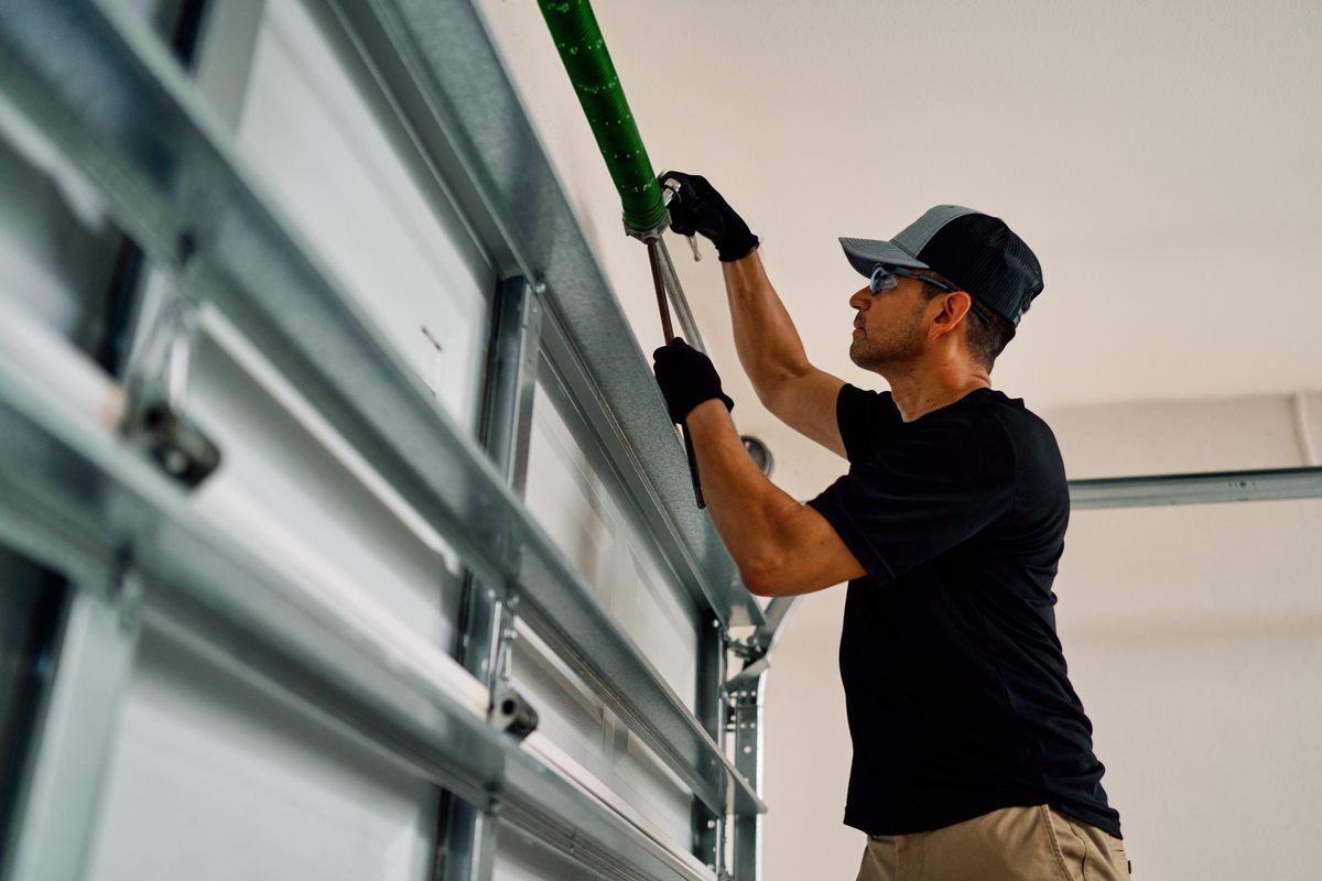 Precision Garage Door technician repairing garage door spring in Des Moines